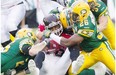 Calgary Stampeders’ Marquay McDaniel, centre, is tackled by Edmonton Eskimos’ Mike Miller, left, and Donovan Richard, centre right, during first half Canadian Football League game action in Edmonton on Friday Sept. 6, 2013.
Photograph by: JASON FRANSON, THE CANADIAN PRESS