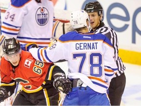 Calgary Flames forward Turner Elson tries to break free from the clutches of Edmonton Oilers defenceman Martin Gernat during a game between the teams' prospects during the Young Stars tournament in Penticton, B.C., on Sept. 5, 2013.