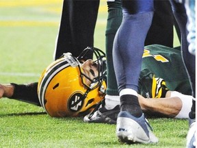 Edmonton Eskimos QB #13 Mike Reilly lays on the field after a crushing hit against the Toronto Argonauts during CFL action at Commonwealth Stadium in Edmonton, September 28, 2013. Backup QB Kerry Joesph took over the duties.
Photograph by: Ed Kaiser, Edmonton Journal
