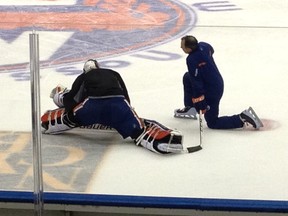 Devan Dubnyk stretches alongside goaltending coach Frederic Chabot after morning skate at Nassau Coliseum.