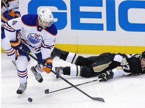 Down but not out: Sidney Crosby was a thorn in Edmonton Oilers' side all night on Tuesday. Here a prone Crosby pokes the puck away from Taylor Hall. (Photograph by: Gene J. Puskar, AP)