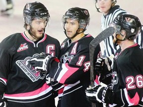 Brady Brassart, centre, celebrates his first of two second period goals against the Lethbridge Hurricanes at the Saddledome on Sunday with captain Jayden Rissling and winger Zane Jones. Jake Virtanen had already potted three by the time Brassart went on his scoring spree in a 6-3 Calgary win.