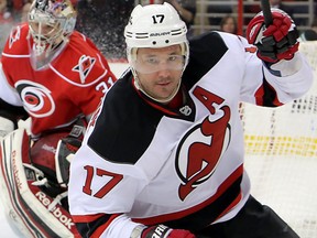 In this March 9, 2013, file photo, New Jersey Devils' Illya Kovalchuk (17), of Russia, skates away after scoring against Carolina Hurricanes' Dan Ellis, center, and Jay Harrison, left, during an NHL hockey game in Raleigh, N.C. Kovalchuk is retiring from the NHL and returning to Russia. The Devils announced the stunning news Thursday afternoon, July 11, 2013, in a statement, saying that the 30-year-old Kovalchuk had alerted general manager and president Lou Lamoriello earlier this year that he wanted to return home with his family after 11 seasons in the NHL.
