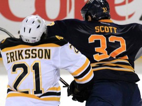 Buffalo Sabres John Scott (32) checks Boston Bruins Loui Eriksson (21) during third period action at the First Niagara Center in Buffalo on Wednesday, Oct. 23, 2013. Scott has been suspended indefinitely by the NHL pending a disciplinary hearing for a blindside hit to the head that levelled Eriksson.