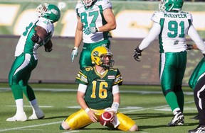 Edmonton Eskimos quarterback Matt Nichols shows his frustration after being sacked as Saskatchewan Roughriders’ Tearrius George (93) Aaron Hargreaves (87) and Jermaine McElveen (91) celebrate on Friday at Commonwealth Stadium.
Photograph by: JASON FRANSON , THE CANADIAN PRESS