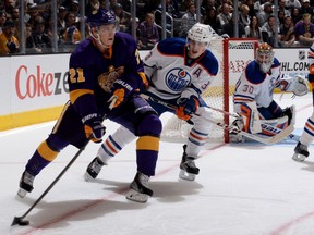 Matt Frattin #21 of the Los Angeles Kings skates with the puck against Ryan Nugent-Hopkins #93 of the Edmonton Oilers at Staples Center on October 27, 2013 in Los Angeles.