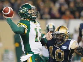 Edmonton Eskimos’ quarterback Mike Reilly, left, gets a pass away under pressure from Winnipeg Blue Bombers’ Henoc Muamba during first half CFL action in Winnipeg on Friday, Sept. 20, 2013.
Photograph by: John Woods, THE CANADIAN PRESS