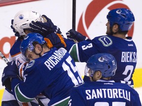 This photo pretty much sums up Saturday night's game as Kevin Bieksa and his bully-boy pals mugged Taylor Hall and the Edmonton Oilers. (Photo by Ben Nelms/Getty Images)