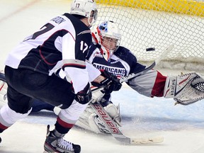 Vancouver Giants Mark Tvrdon(L) finds the open space over the shoulder of Tri-City Americans goalie Eric Comrie(R) in third period WHL play Friday, January  13, 2012 at the Pacific Coliseum in Vancouver.