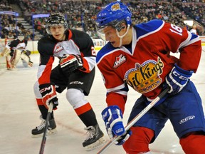 Reid Petryk of the Edmonton Oil Kings, picks up the puck in to the corner an is watched by Sam Ruopp of the Prince George Cougars of the Western Hockey League at Rexall Place in Edmonton.
