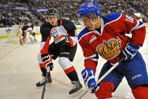 Reid Petryk of the Edmonton Oil Kings, picks up the puck in to the corner an is watched by Sam Ruopp of the Prince George Cougars of the Western Hockey League at Rexall Place in Edmonton.