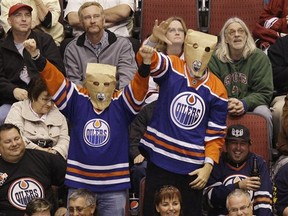 Two Edmonton Oilers fans celebrate the Oilers lone goal against the Phoenix Coyotes in the third period of an NHL hockey game Monday, Feb. 8, 2010, in Glendale, Ariz.  The Coyotes defeated the Oilers 6-1. (AP Photo/Ross D. Franklin)