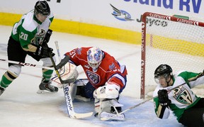 Prince Albert Raiders Shane Danyluk tries to get the puck past Regina Pats goalie Dawson MacAuley as Raiders Reid Gardiner trips backwards in Regina on Friday, Nov. 29, 2013.