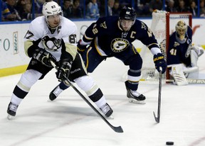 Pittsburgh Penguins' Sidney Crosby, left, passes the puck as St. Louis Blues goalie Jaroslav Halak (41), of Slovakia, and David Backes, center, watch during their NHL game Nov. 9, 2013, in St. Louis. The Blues won 2-1.