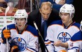 Former Edmonton Oilers head coach Ralph Krueger, centre, talks to Taylor Hall, right, as Ryan Nugent-Hopkins, looks on during the third period of an NHL hockey game against the Vancouver Canucks in Vancouver, B.C., on Sunday January 20, 2013.