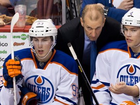 Former Edmonton Oilers head coach Ralph Krueger, centre, talks to Taylor Hall, right, as Ryan Nugent-Hopkins, looks on during the third period of an NHL hockey game against the Vancouver Canucks in Vancouver, B.C., on Sunday January 20, 2013.