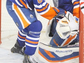 Edmonton Oilers left wing Nail Yakupov (64) crashes into teammate and goalie Devan Dubnyk during the first period of NHL action in Edmonton, Alta., on Monday, November 25, 2013. THE CANADIAN PRESS/John Ulan