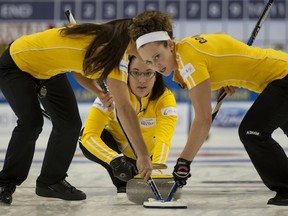 Rachelle Pidherny, left, and Joanne Courtney sweep skip Val Sweeting&#039;s rock during Saturday morning&#039;s women&#039;s playoff game in the Capital One Road to the Roar Olympic curling pre-trials  at the Kitchener Memorial Auditorium at Kitchener, Ont.