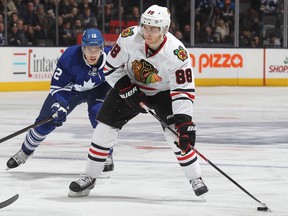 Patrick Kane of the Chicago Blackhawks breaks towards the Toronto Maple Leafs goal while being checked by Mason Raymond during an National Hockey League game at the Air Canada Centre in Toronto on Dec. 14, 2013.