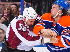 Luke Gazdic #20 of the Edmonton Oilers fights Patrick Bordeleau #58 of the Colorado Avalanche during an NHL game at Rexall Place on December 5, 2013.