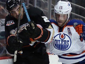 Anaheim Ducks forward Kyle Palmieri is checked into the boards by Edmonton Oilers defenceman Nick Schultz at the Honda Center on Dec. 15, 2013 in Anaheim.