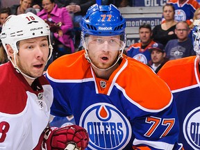 Edmonton Oilers defenceman Anton Belov, right, defends against Phoenix Coyotes forward David Moss at Rexall Place on Dec. 3, 2013