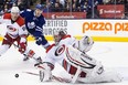 Carolina Hurricanes goaltender Cam Ward slides but fails to stop Toronto Maple Leafs' Phil Kessel (not shown) from scoring as Hurricanes defenceman Ron Hainsey and the Maple Leafs' James van Riemsdyk look on during a NHL game at the Air Canada Centre in Toronto on Dec. 29, 2013.