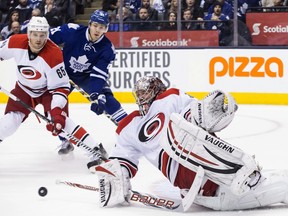 Carolina Hurricanes goaltender Cam Ward slides but fails to stop Toronto Maple Leafs' Phil Kessel (not shown) from scoring as Hurricanes defenceman Ron Hainsey and the Maple Leafs' James van Riemsdyk look on during a NHL game at the Air Canada Centre in Toronto on Dec. 29, 2013.