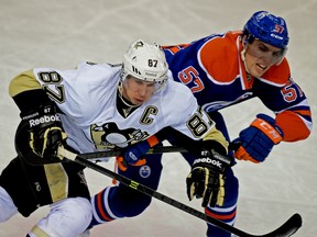 Pittsburgh Penguins captain Sidney Crosby is checked by Edmonton Oilers' David Perron during a National Hockey League game at Rexall Place on  Jan. 10, 2014.