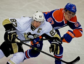 Pittsburgh Penguins captain Sidney Crosby is checked by Edmonton Oilers' David Perron during a National Hockey League game at Rexall Place on  Jan. 10, 2014.