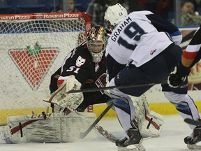 Calgary Hitmen goalie Mack Shields makes a save on Saskatoon Blades forward Ryan Graham during WHL action at Saskatoon's Credit Union Centre on Wednesday, Jan. 8, 2014.