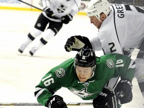 Dallas Stars left wing Ryan Garbutt is checked to the ice by Los Angeles Kings defenceman  defenseman Matt Greene in a National Hockey League game in Dallas on Dec. 31, 2013.