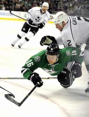 Dallas Stars left wing Ryan Garbutt is checked to the ice by Los Angeles Kings defenceman  defenseman Matt Greene in a National Hockey League game in Dallas on Dec. 31, 2013.