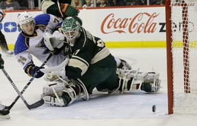 St. Louis Blues right wing T.J. Oshie scores on Minnesota Wild goalie Josh Harding during an NHL game at St. Paul, Minn., on Dec. 31, 2013.