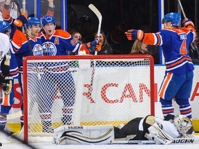 Edmonton Oilers Justin Schultz (obscured at far left), Jordan Eberle, Ryan Nugent-Hopkins and Taylor Hall celebrate the game-winning goal on an overtime powerplay.