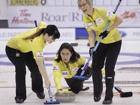 Renee Sonnenberg watches her rock as second Cary-Anne McTaggart, left, and lead Rona Pasika get ready to sweep during a Roar of the Rings Canadian Olympic trials curling game at the MTS Centre in Winnipeg on Dec. 2, 2013. The winners of Roar Of The Rings will represent Canada at the Sochi Olympics and the trials run from Dec 1-8.