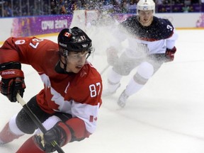 Canada's Sidney Crosby (87) vies for the puck against US Cam Fowler (3) during the Men's Ice Hockey Semifinals USA vs Canada at the Bolshoy Ice Dome during the Sochi Winter Olympics on February 21, 2014.   AFP PHOTO / JONATHAN NACKSTRANDJONATHAN NACKSTRAND/AFP/Getty Images