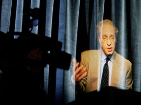 A cameraman tries to get an angle on a hologram of American inventor Ray Kurzweil who was giving a speech from Boston.