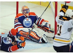 Aftermath: Drew Stafford celebrates his goal that has just clinched Buffalo Sabres' 3-1 victory over Edmonton Oilers on Thursday night. Oilers goaltender Ben Scrivens and right wing (!) David Perron assume unconventional poses at the end of a long sequence of pain.