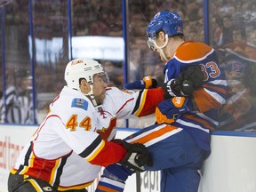 Ales Hemsky of the Edmonton Oilers gets checked into the board by Calgary Flames's Chris Butler during a National Hockey League game at Rexall Place on March 1, 2014.