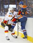 Ales Hemsky of the Edmonton Oilers gets checked into the board by Calgary Flames's Chris Butler during a National Hockey League game at Rexall Place on March 1, 2014.