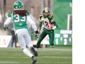 Edmonton Eskimos quarterback Mike Reilly runs the ball as Saskatchewan Roughriders defensive back Dwight Anderson looks on during the second quarter of CFL football action in Regina, Sask., Saturday, November 2, 2013. THE CANADIAN PRESS/Liam Richards
Photograph by: Liam Richards, THE CANADIAN PRESS