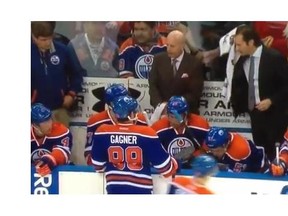A screen shot from a YouTube video as Oiler Coach Dallas Eakins towels off after getting sprayed when Taylor Hall slammed a water bottle in frustration at the bench during a lopsided loss to the Calgary Flames on March 22, 2014.
