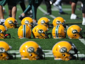 Players line up helmets while doing drills during the Edmonton Eskimos Training Camp at Clarke Park in Edmonton on Saturday June 7, 2014.