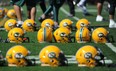 Players line up helmets while doing drills during the Edmonton Eskimos Training Camp at Clarke Park in Edmonton on Saturday June 7, 2014.