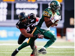 Edmonton Eskimos’ Shamawd Chambers, right, tries to get away from Calgary Stampeders’ Maalik Bomar during second-half CFL football action in Calgary on Sept. 1, 2014. The Stampeders improved to 8-1 with a 28-13 victory.
Photograph by: Jeff McIntosh, THE CANADIAN PRESS