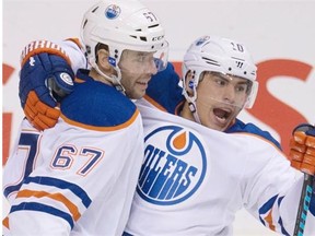 Nail Yakupov and Benoit Pouliot celebrate a goal. (Photo: Jonathan Hayward/Canadian Press)