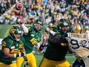 EDMONTON, AB - OCTOBER 13:  Mike Reilly #13 of the Edmonton Eskimos makes a pass against the Winnipeg Blue Bombers during a CFL game at Commonwealth Stadium on October 13, 2014 in Edmonton, Alberta, Canada. (Photo by Derek Leung/Getty Images)