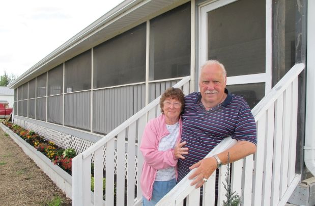 Evan and Arlene McDonald stand outside the double mobile home they bought from Arnold Donszelmann in 2010.