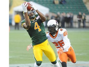 Adarius Bowman (4) of the Edmonton Eskimos, hauls in a pass against Cord Parks (26) of the B.C. Lions at Commonwealth Stadium in Edmonton.